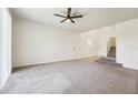 Spacious living room with carpeting leading to a staircase and a tiled entrance at 5955 Sweet Birch Dr, Riverview, FL 33578