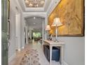 Elegant foyer features a decorative ceiling, chandelier, and large artwork for a grand entrance at 9708 Highland Park Pl, Palmetto, FL 34221