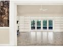 Bright living room featuring a stone fireplace, built-in shelving, and sliding glass doors to the outdoor patio at 11712 Palmer Dr, Tampa, FL 33624