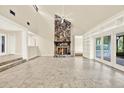Spacious living room featuring a stone fireplace and built-in shelving with views of the outdoor space at 11712 Palmer Dr, Tampa, FL 33624