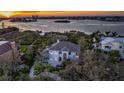 Aerial view of estate with water views at sunset, nestled among mature trees at 12808 Harborwood Dr, Largo, FL 33774