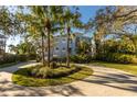 Stately home showcasing mature palm trees and a circular driveway, enhancing its curb appeal at 12808 Harborwood Dr, Largo, FL 33774