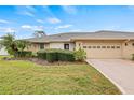 Charming single-story home with a well-manicured lawn, mature trees, and an attached two-car garage at 1319 Leland Dr # 101, Sun City Center, FL 33573