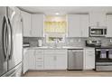 Modern kitchen featuring white cabinets, stainless appliances, and granite countertops at 1319 Leland Dr # 101, Sun City Center, FL 33573