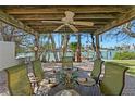 Charming outdoor dining area under a wooden pergola with water views, perfect for entertaining or relaxing at 222 Mar St, St Pete Beach, FL 33706
