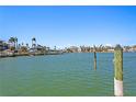 Scenic waterfront view featuring calm green waters, waterfront homes, docks, and palm trees under a clear blue sky at 222 Mar St, St Pete Beach, FL 33706
