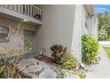 Front entry with small garden of plants, white stones and stepping stones, plus a view of a second story balcony at 2625 State Road 590 # 2612, Clearwater, FL 33759