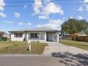Charming home with a covered carport, well-manicured lawn, and beautifully painted in white at 2901 W Nassau St, Tampa, FL 33607