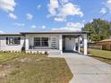 Charming home with a covered carport, well-manicured lawn, and beautifully painted in white at 2901 W Nassau St, Tampa, FL 33607