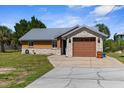 Charming single-story home with stone accents, metal roof, well-manicured lawn, and inviting curb appeal at 3609 Flamingo Blvd, Hernando Beach, FL 34607
