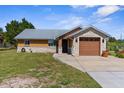 Charming single-story home with stone accents, metal roof, well-manicured lawn, and inviting curb appeal at 3609 Flamingo Blvd, Hernando Beach, FL 34607