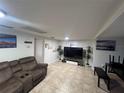 Living room featuring tile floors, white walls and a brown sofa at 37324 Rose Ave, Dade City, FL 33523