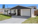 Charming single-story home with solar panels, white brick, and dark trim at 4750 Foothill Dr, Holiday, FL 34690