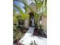 Welcoming front entrance with beautiful landscaping, complemented by a bright white walkway at 5229 Clover Mist Dr, Apollo Beach, FL 33572