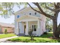 Beautiful two-story home featuring a light gray exterior, covered front porch, and mature landscaping at 5337 6Th N Ave, St Petersburg, FL 33710