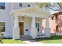 Inviting front porch with white columns, wood door, brick path, and a hanging lantern above the address at 5337 6Th N Ave, St Petersburg, FL 33710
