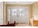 Welcoming entryway featuring decorative glass double doors and complementing side panel windows at 7440 Mint Julep Dr, Riverview, FL 33578