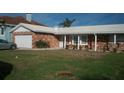 Charming brick home featuring a well-manicured lawn, attached garage and classic architectural details at 780 116Th Ave, Treasure Island, FL 33706