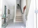 Bright foyer features tiled floor, staircase, console table, and access to living spaces at 923 Arlington N Ave, St Petersburg, FL 33705