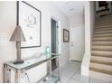 Elegant foyer with tile flooring, staircase, designer console table, and stylish decor at 923 Arlington N Ave, St Petersburg, FL 33705