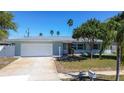Beautiful home with a large garage and a driveway, nestled on a lush green lawn at 10915 Hammock Dr, Largo, FL 33774