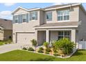 Attractive two-story home with a welcoming front porch, beautifully landscaped yard, and a convenient two-car garage at 11617 Miracle Mile Dr, Riverview, FL 33578