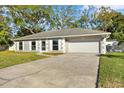 Charming single-story home with a well-maintained lawn, attached two-car garage, and a concrete driveway at 13911 Briardale Ln, Tampa, FL 33618