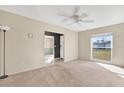 Inviting living room with neutral paint, plush carpet, ceiling fan, and natural light from large window at 13911 Briardale Ln, Tampa, FL 33618