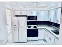 Bright kitchen with white cabinets, granite countertops, and black backsplash at 1620 58Th Ave. S. # 1, St Petersburg, FL 33712