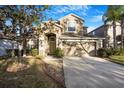 Inviting two-story home with a two-car garage, stone accents, and a landscaped front yard at 20427 Carolina Cherry Ct, Tampa, FL 33647