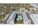 Aerial view of the complex with a central pool and mature trees, nestled in a residential area at 215 Valencia Blvd # 205, Belleair Bluffs, FL 33770
