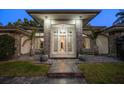 An inviting front entrance with custom stone columns, decorative plants, and statement lighting at 217 Manatee Rd, Belleair, FL 33756
