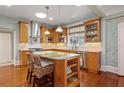 Bright kitchen featuring a large island with seating, stainless steel appliances, wood cabinets and tiled backsplash at 235 Aberdeen St, Dunedin, FL 34698