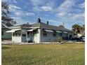 Classic single-story home with gray exterior, awning-covered windows, and a well-maintained lawn at 3001 57Th S St, Gulfport, FL 33707