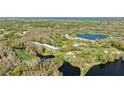 Scenic aerial shot showcasing condos nestled within a golf course and surrounding water features at 36750 Us Highway 19 N # 3-210, Palm Harbor, FL 34684