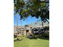 Brick condo building featuring a unique roofline and lush landscaping, inviting you to your new home at 36750 Us Highway 19 N # 3-210, Palm Harbor, FL 34684