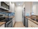 Well-equipped kitchen features stainless steel appliances, tile backsplash, and neutral cabinetry with ample storage at 407 Feltham Trl # A, Sun City Center, FL 33573