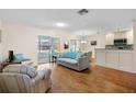 Bright and airy living room with hardwood floors, neutral paint, access to a screened lanai, and open to the dining area at 407 Feltham Trl # A, Sun City Center, FL 33573