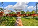 Inviting two-story home with a manicured front lawn, a wooden fence, and a brick walkway leading to the entrance at 4205 1St N Ave, St Petersburg, FL 33713