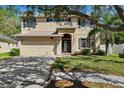 Two story home featuring a two car garage, neutral paint, dark shutters, landscaped yard and mature trees at 4821 Barchetta Dr, Land O Lakes, FL 34639