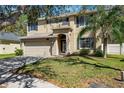 Two story home featuring a two car garage, neutral paint, dark shutters, landscaped yard and mature trees at 4821 Barchetta Dr, Land O Lakes, FL 34639