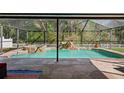 Screened pool with spa and waterfall feature surrounded by lush landscaping for a private backyard oasis at 4821 Barchetta Dr, Land O Lakes, FL 34639