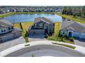 Aerial view of a lovely home with a spacious yard and a serene lake backdrop in a residential area at 4904 Eagle Rock Dr, Wimauma, FL 33598