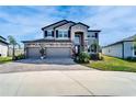 Beautiful two-story home featuring a three-car garage, stone accents, and manicured landscaping at 4904 Eagle Rock Dr, Wimauma, FL 33598