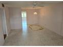 Empty living room featuring vintage chandelier and ceiling fan ready for decorating and new flooring at 5095 Bay Ne St # 310, St Petersburg, FL 33703