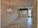 Empty living room featuring vintage chandelier and ceiling fan ready for decorating and new flooring at 5095 Bay Ne St # 310, St Petersburg, FL 33703