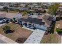 An aerial view of a single-story home with solar panels, showcasing the driveway and surrounding neighborhood at 663 Allegheny Dr, Sun City Center, FL 33573