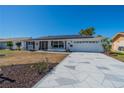 A lovely single-story home boasting a geometrically patterned driveway and solar panels on the roof at 663 Allegheny Dr, Sun City Center, FL 33573