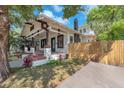 Side view of charming bungalow featuring a front porch with columns, brick steps, and mature landscaping at 710 E Plymouth St, Tampa, FL 33603