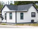 Exterior side view of white home with black trim and dark gray roof at 710 Seminole, Clearwater, FL 33755